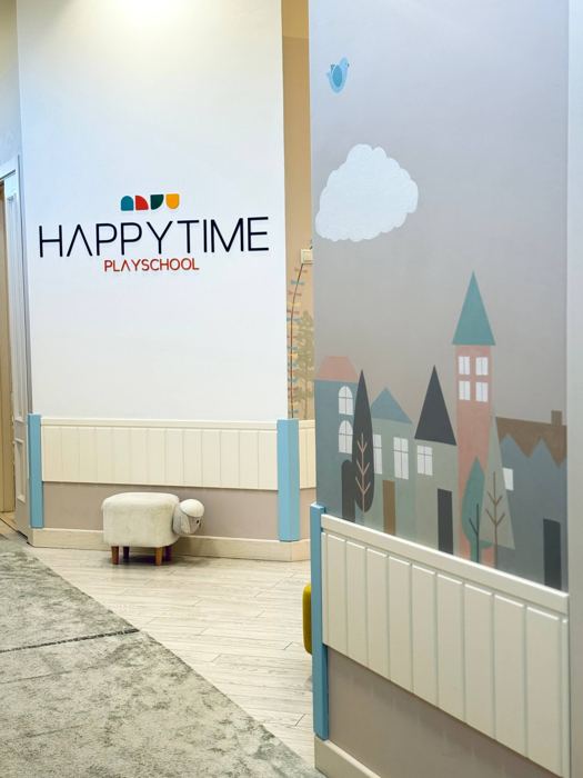 Холл с логотипом Happy Time и росписью городка